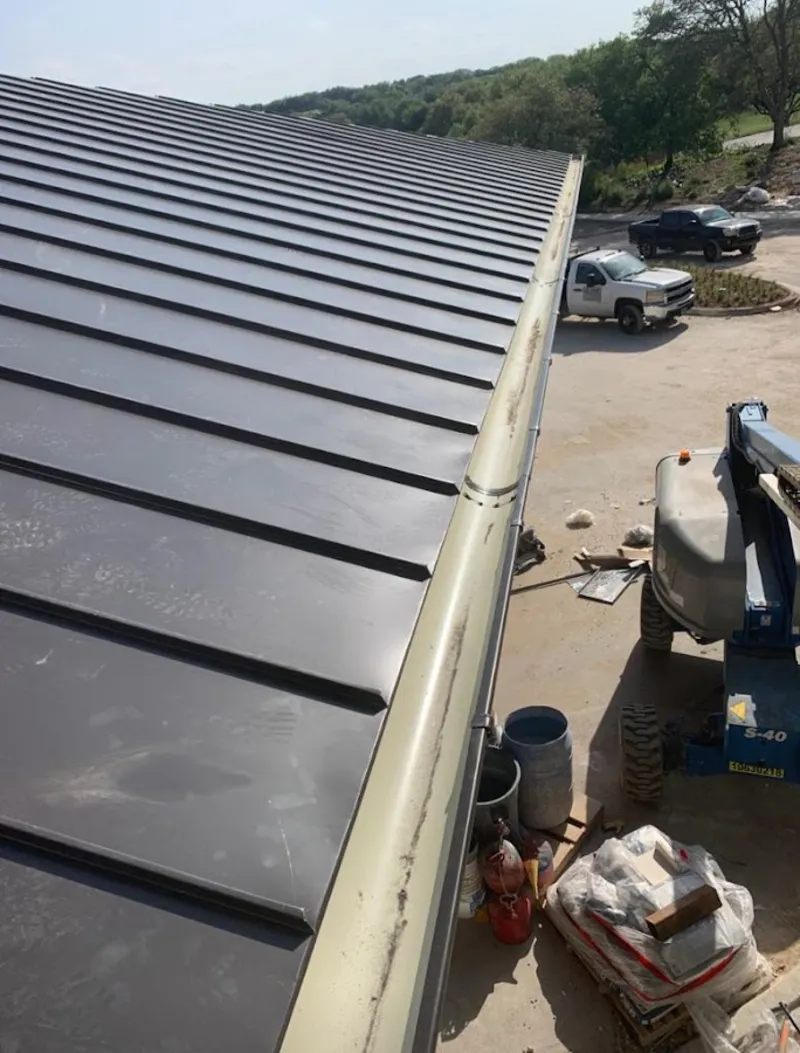 Standing seam panel and gutter detail on a metal roofing jobsite in Kingsland